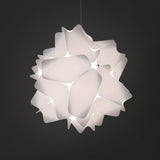 A white matte pendant lamp shade with a geometric design, featuring precisely cut rectangles and softly rounded corners, suspended from a ceiling.