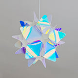 Pink and blue iridescent spherical lampshade with star- or petal-like patterns, hanging from the ceiling with the light turned off.